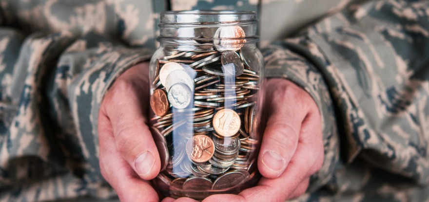 US military serviceman holding jar full of coins   ©iStockphoto.com/Catherine Lane