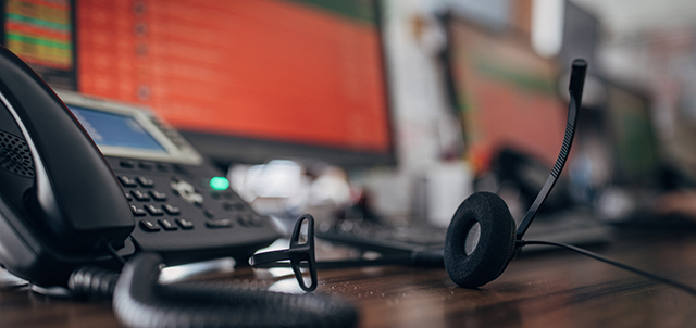 A desk phone and computer monitor