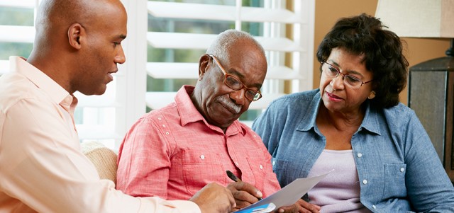 Financial Advisor Talking To Senior Couple At Home